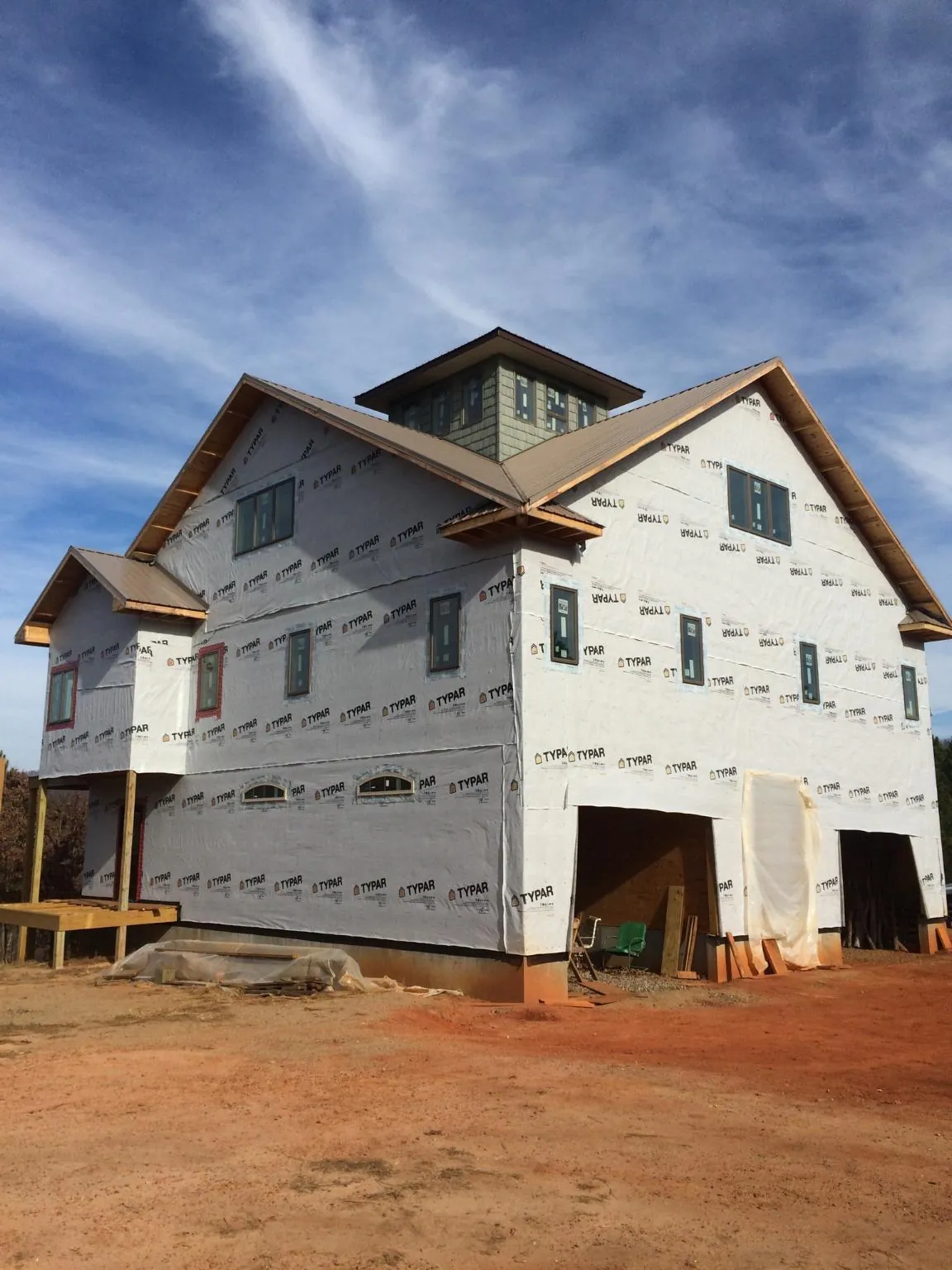 New two story house under construction with a cupola and gabled roofs in Yukon